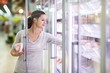 © lightpoet - Young woman shopping for meat in a grocery store