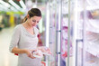 © lightpoet - Young woman shopping for meat in a grocery store