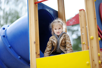 Wall Mural - Adorable girl having fun on a playground