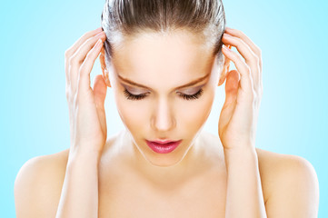 Beautiful young woman with hands on head, studio shot