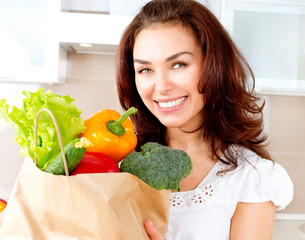 Happy Young Woman with vegetables in shopping bag. Diet Concept