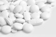 White pills and tablets on white background