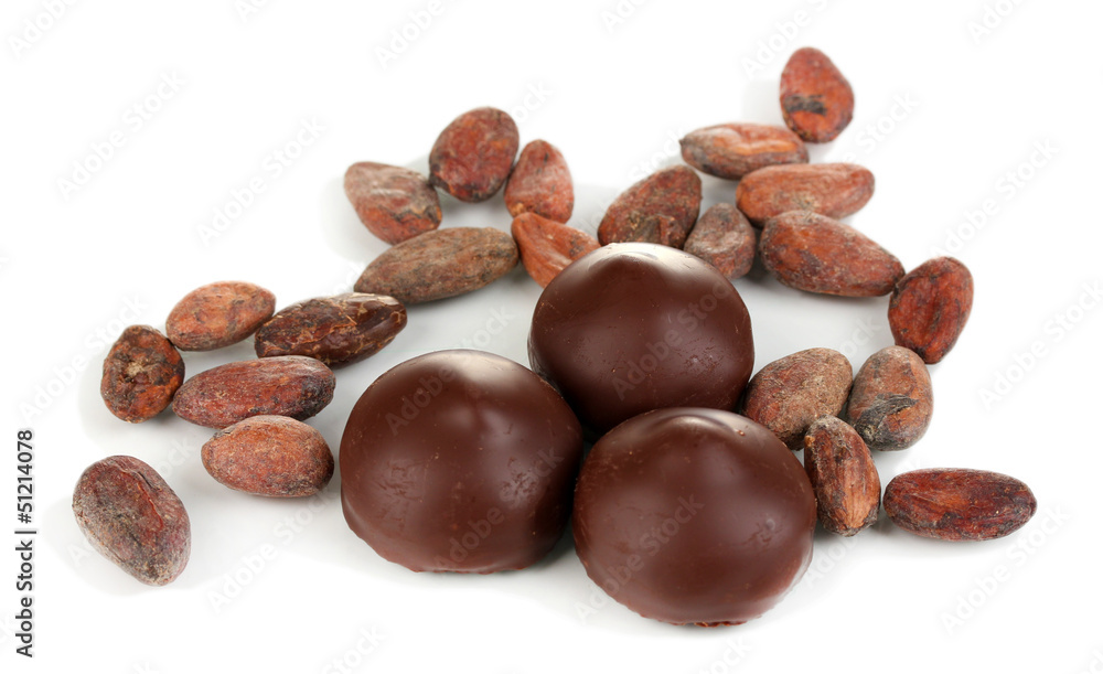 Chocolate candies and cocoa beans isolated on white