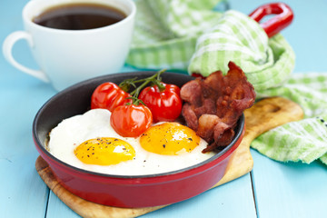 Fried eggs with bacon and tomatoes