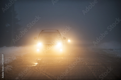Fényképezés  Headlights of car driving in fog