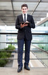 © cristovao31 - Smiling young businessman using his digital tablet at the office