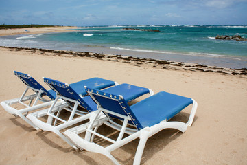 calm beach with deckchairs under the blue sky