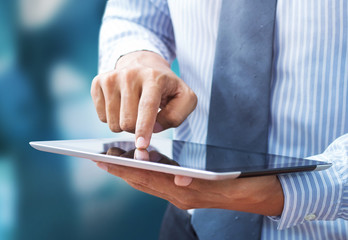 Business hand presses on screen digital tablet