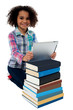© stockyimages - Smiling child busy with tablet pc and books