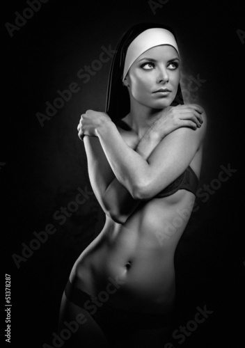 Naklejka na drzwi Sexy young nun posing indoors, black and white photo