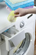Woman pouring washing powder into the washing machine