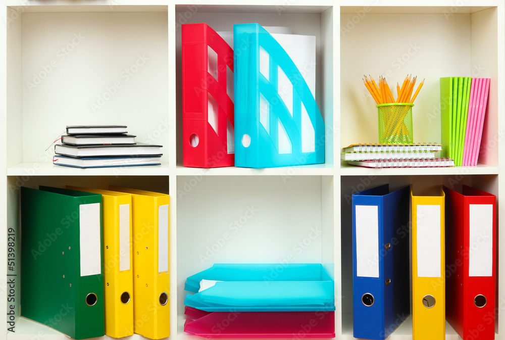 White office shelves with different stationery, close up