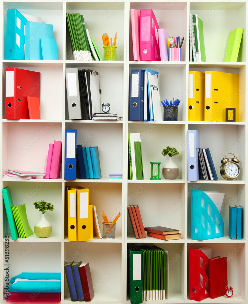 White office shelves with different stationery, close up