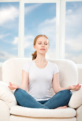 Wall Mural - woman meditating, relaxing, sitting in a lotus position on the