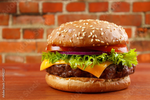 Naklejka samoprzylepna Hamburger na stole z czerwonym tle ceglanego muru