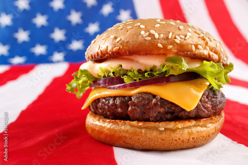 Naklejka samoprzylepna Soczysty grillowany hamburger na tle flaga usa
