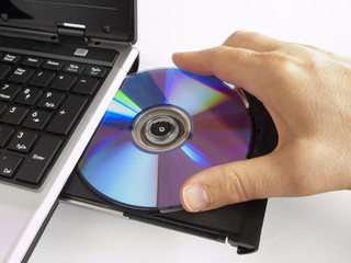 CD ROM in the CD drive of a labtop computer being taken away