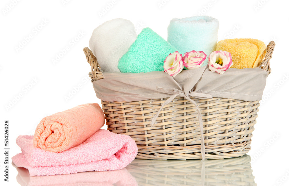 Bathroom towels folded in wicker basket isolated on white