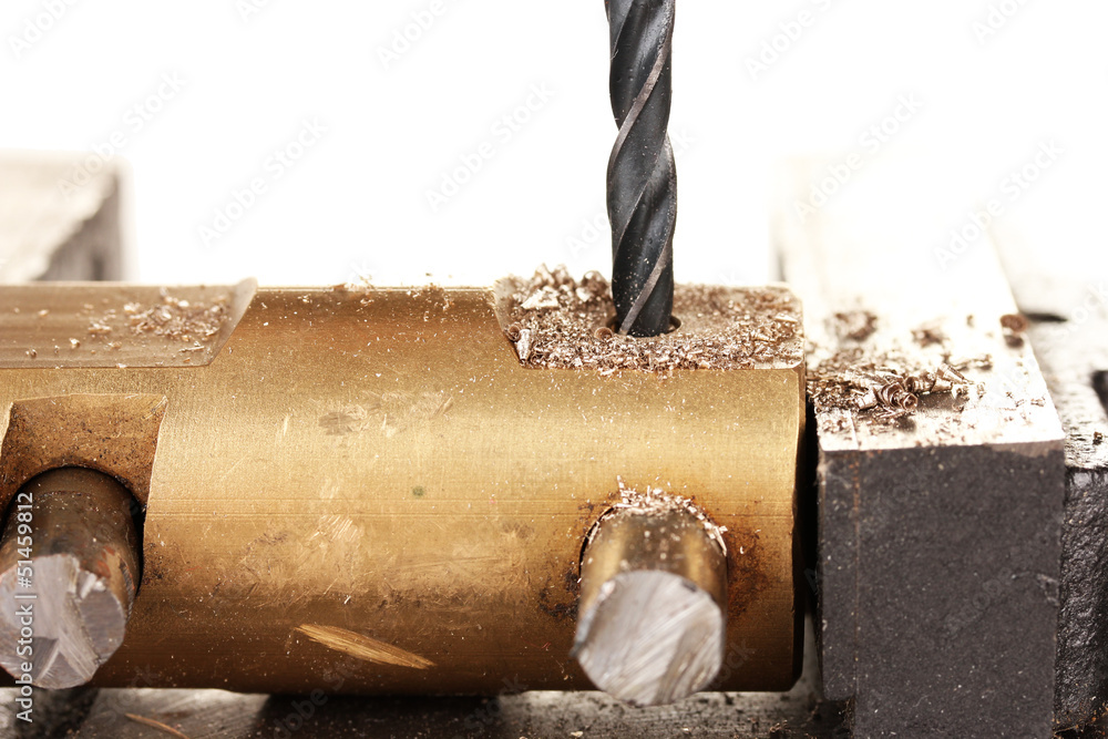 Drilling hole into metal, isolated on white