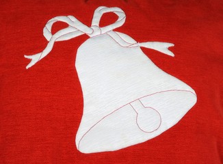 White Christmas bell against red fabric © Arena Photo UK