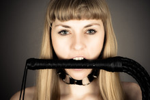Submissive Woman Holding A Whip In His Mouth