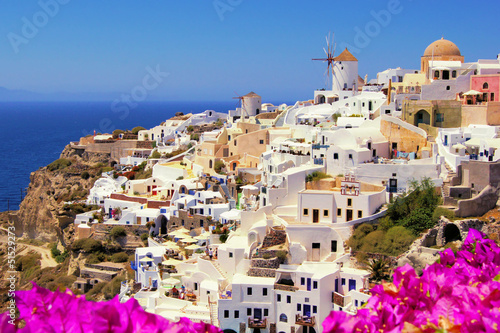 Plakat na papierze fotorealistycznym Piękny klasyczny widok na greckie santorini z kwiatami