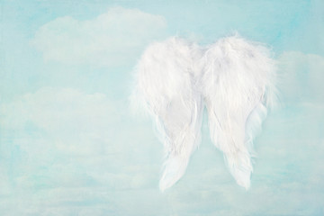 White angel wings on blue sky background