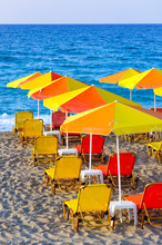 Colorful Umbrellas On The Beach, And Blue Sea At The Background