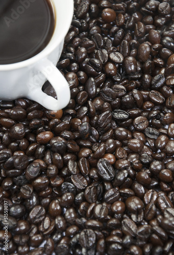 Fototapeta na wymiar A cup of coffee and coffee beans background