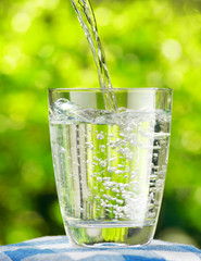 Sticker - Glass of water on nature background