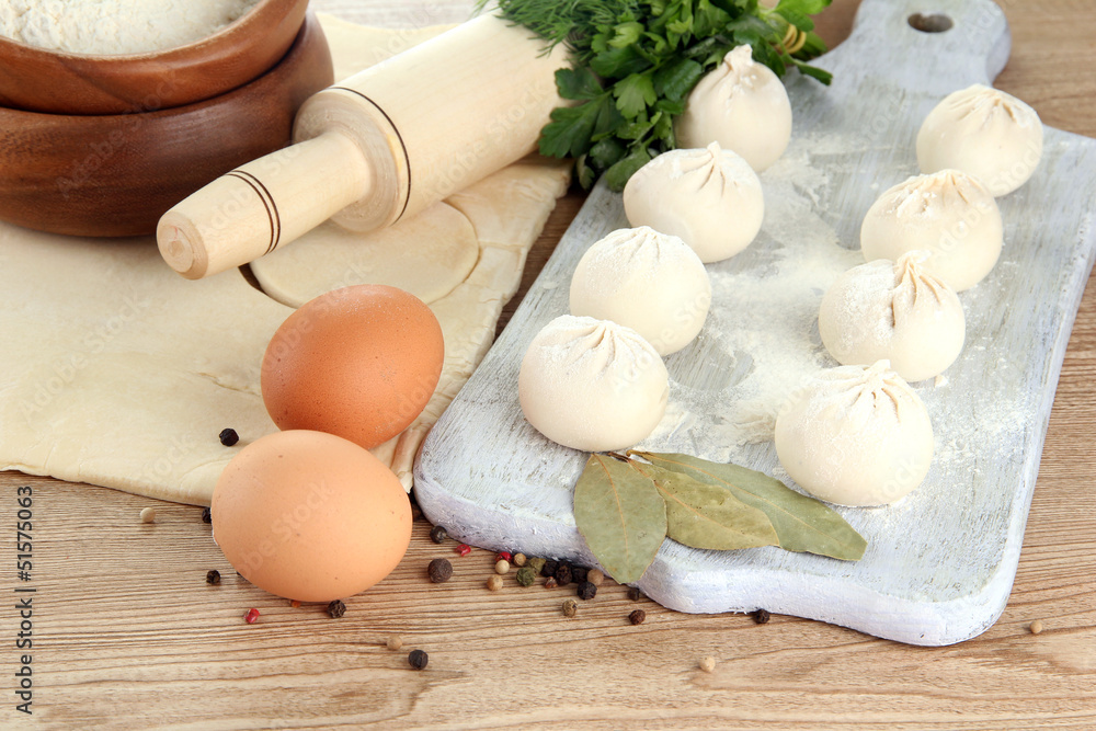 Raw dumplings, ingredients and dough, on wooden table