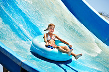 Child On Water Slide At Aquapark.