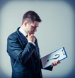 © slasnyi - businessman holding a white billboard with a question mark