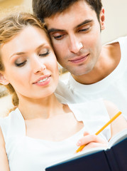 Canvas Print - Cheerful couple with organizer, indoors