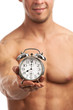 © Andrey Bandurenko - Muscular young man holding clock. It is time for workout concept