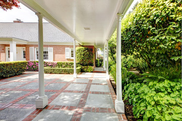 Wall Mural - Brick red house with English garden and white window shutters.