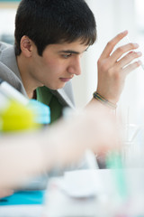 Wall Mural - male student with group of classmates on background working at t