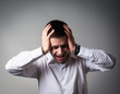 © slasnyi - Young businessman holding head in his hands