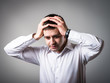 © slasnyi - Young businessman holding head in his hands