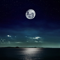 full moon reflected on the beach