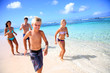 Family running on a paradisaical beach