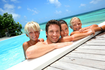 Wall Mural - Family of four bathing in swimming pool