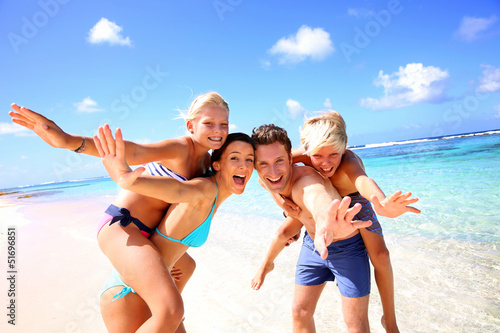Fototapeta na wymiar Family of four having fun at the beach