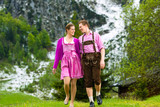 Fototapeta Las - Happy couple hiking in Alpine meadow