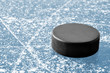 black hockey puck on ice rink