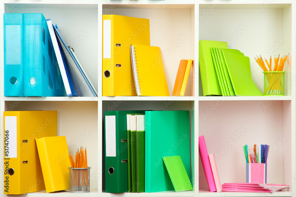 White office shelves with different stationery, close up