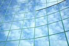 Reflections Of Blue Sky And Clouds In Curved Facade