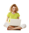 © shefkate - A young girl sitting on the floor with a laptop
