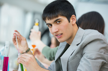 Wall Mural - high school students. handsome mixed race guy working at laborat