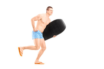 Poster - Full length portrait of a male surfer holding a surfboard and ru